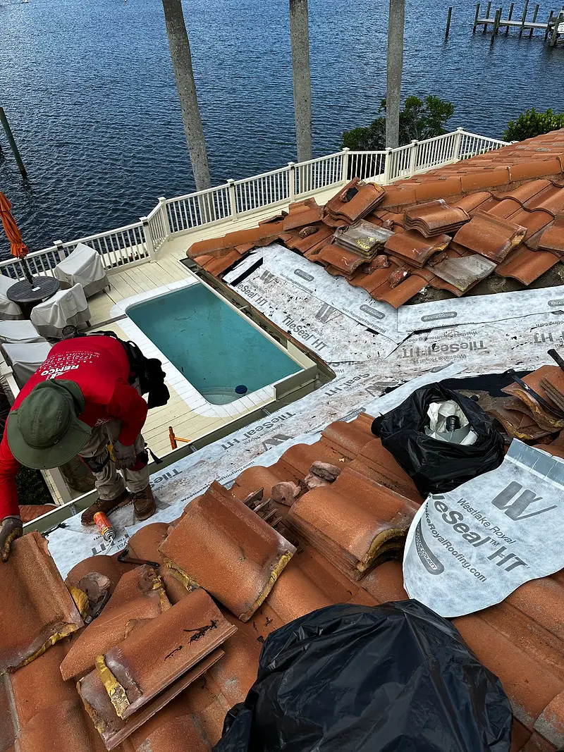 Remco crew re-roofing a waterfront home with barrel tile, pool below